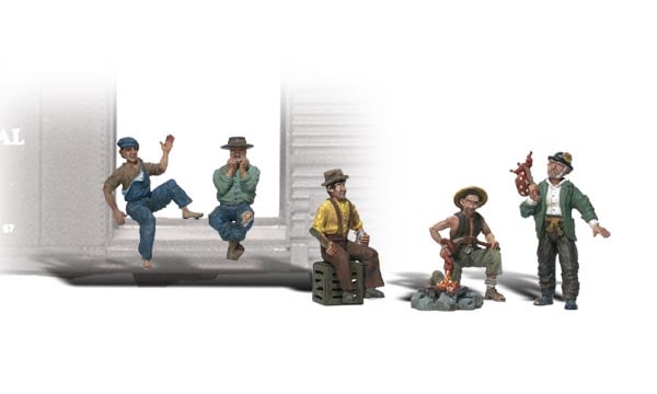 Hobos - N Scale - A man is sitting, one is playing his harmonica, one is sitting on a box, another man is roasting a hot dog and the last man is standing with his knapsack hanging off a stick