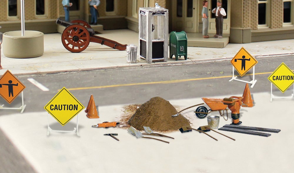 Road Crew Details - N Scale - Set includes an assortment of Road Crew tools and supplies: warning signs, cones, a wheelbarrow, shovels, rakes, poles, a pile of ballast and a bucket